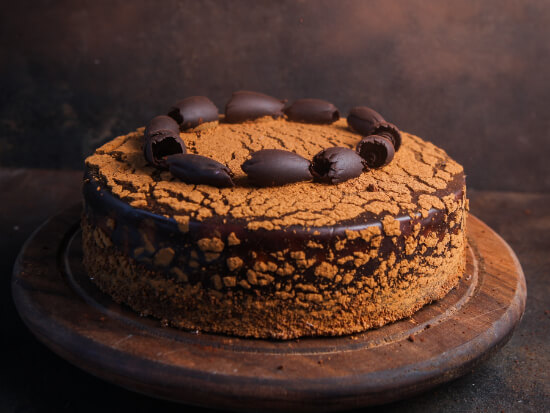 cake-with-chocolate-side-view-grungy-stone-cutting-board